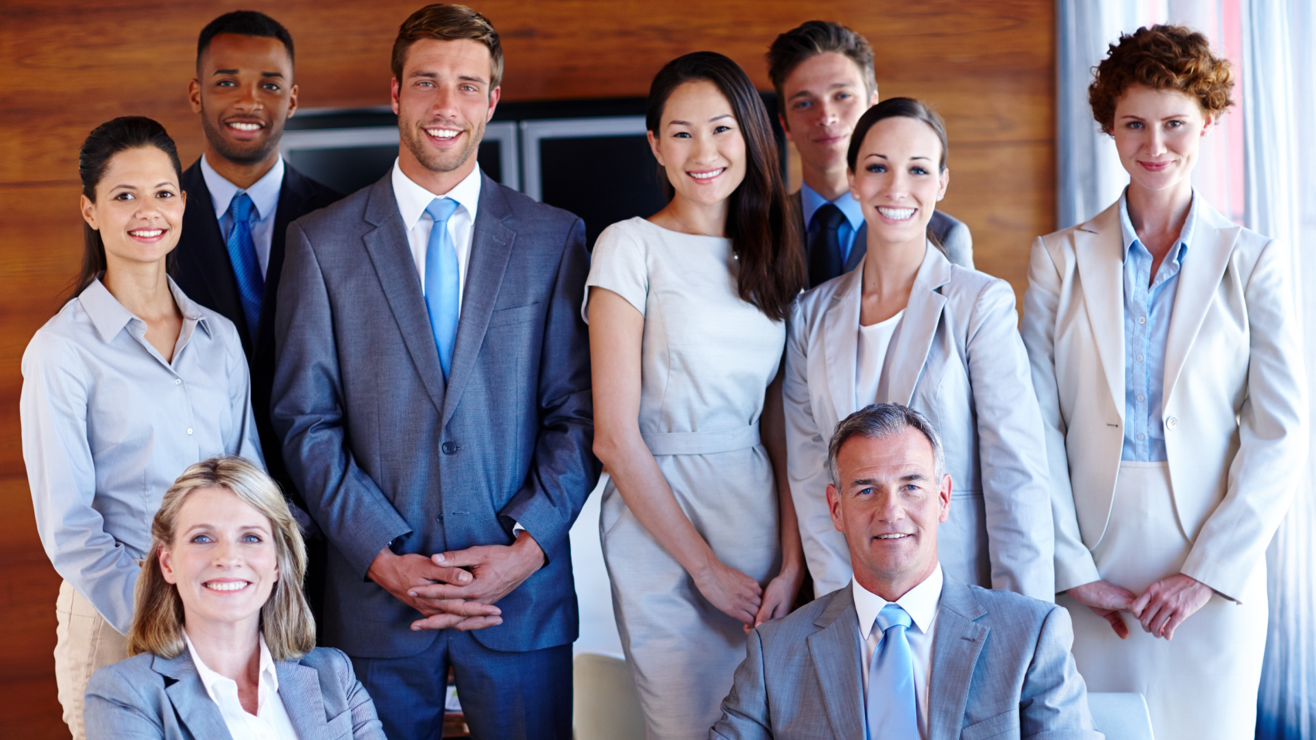 Employees seated together and smiling in an office environment, representing a successful seasonal workforce solution
